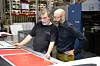 Ralf Vogl und Drucker Zoran Jovanovic begutachten am Leitstand der Rapida 106 einen Flächendruck auf Naturpapier.