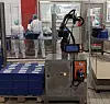 Roboterarm stapelt Verpackungen auf eine Palette