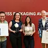 Preisträger vor einer Wand mit der Aufschrift SWISS PACKAGING AWARD