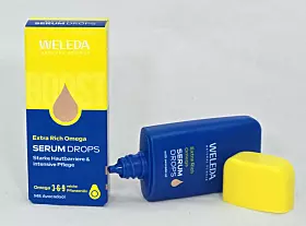 Weleda Serum Drops, Faltschachtel und daneben geöffnet liegend die Produktflasche.