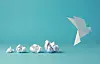Weiße Origami-Taube fliegt neben mehreren zerknüllten Papierkugeln vor blauem Hintergrund